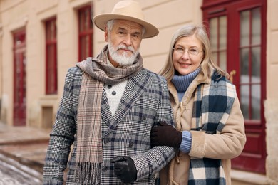 Family portrait of happy elderly couple on city street