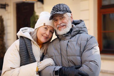 Family portrait of happy elderly couple on city street