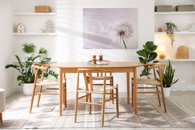 Stylish room with wooden table, chairs and houseplants. Interior design