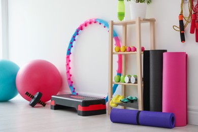 Photo of Different fitness equipment near white wall indoors