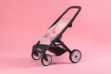 Photo of Stylish doll stroller on pink background. Kid's toy