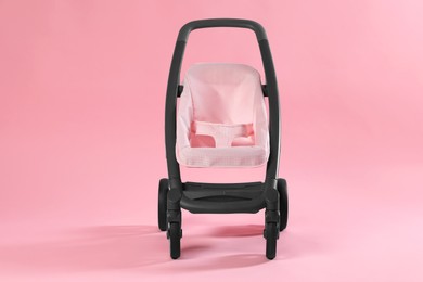 Photo of Stylish doll stroller on pink background. Kid's toy