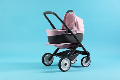 Photo of Doll stroller on light blue background. Kid's toy