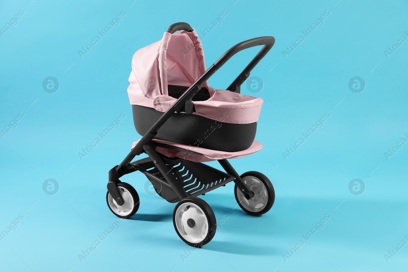 Photo of Doll stroller on light blue background. Kid's toy