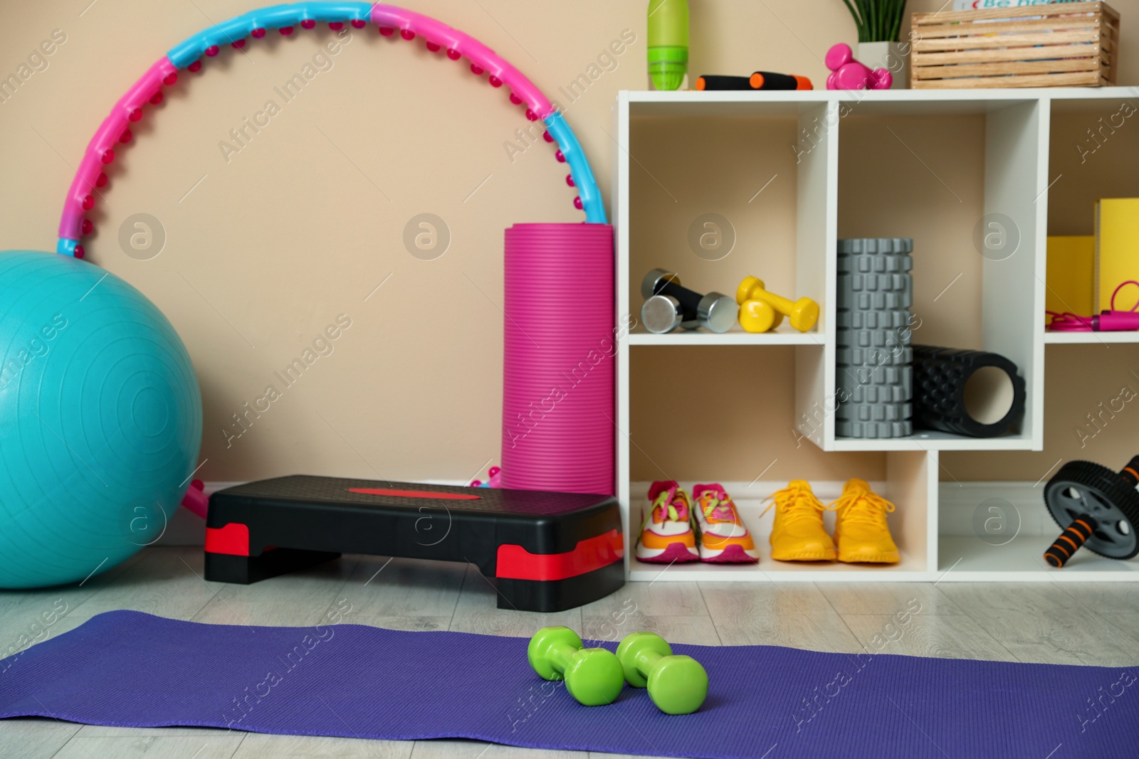 Photo of Different fitness equipment, accessories and sneakers indoors