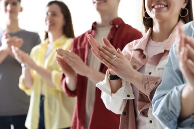 Photo of People applauding during meeting indoors, closeup view