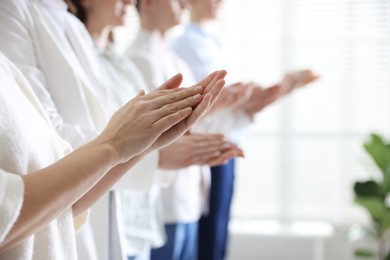 Photo of People applauding during meeting indoors, closeup view