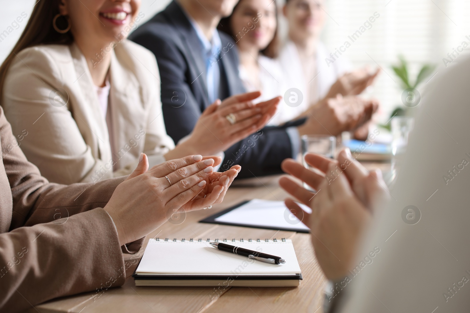 Photo of People applauding at table in office, closeup