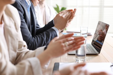 People applauding at table in office, closeup