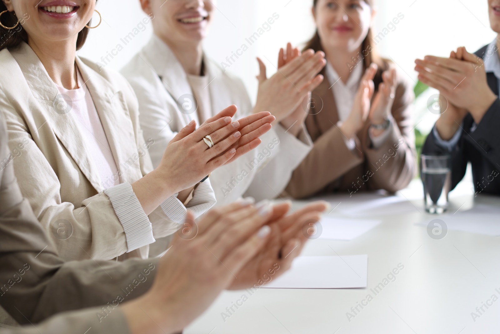 Photo of People applauding at table in office, closeup