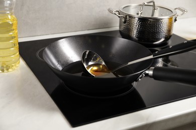 Photo of Used cooking oil and ladle in frying pan on stove