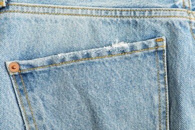 Photo of Ripped light blue jeans with pocket as background, top view