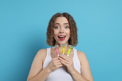 Photo of Emotional woman with different razors on light blue background. Hair removal tools