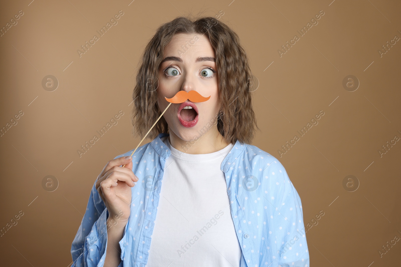 Photo of Funny woman with fake paper mustache on beige background