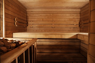 Wooden sauna with bench and hot stones