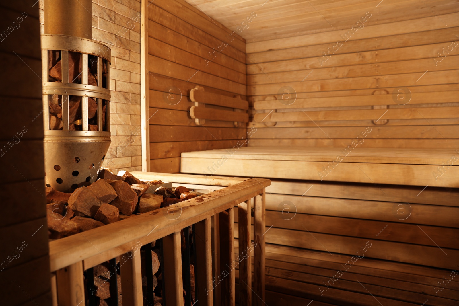 Photo of Wooden sauna with bench, stove and hot stones