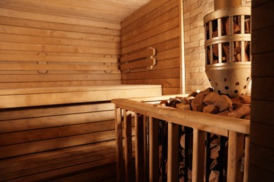 Wooden sauna with bench, stove and hot stones