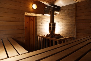 Wooden sauna with bench, stove and hot stones