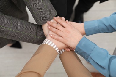 Business concept. Group of people stacking hands indoors, above view