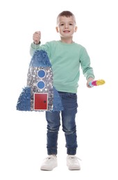 Photo of Happy boy with rocket shaped pinata and stick on white background