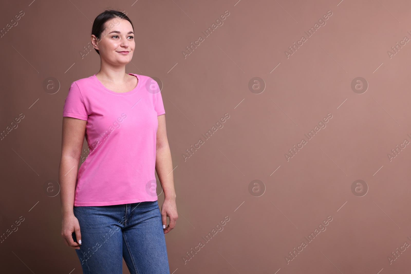 Photo of Woman in pink t-shirt on dark beige background. Mockup for design