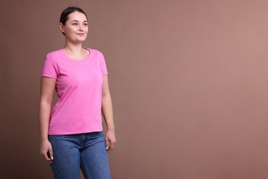 Woman in pink t-shirt on dark beige background. Mockup for design