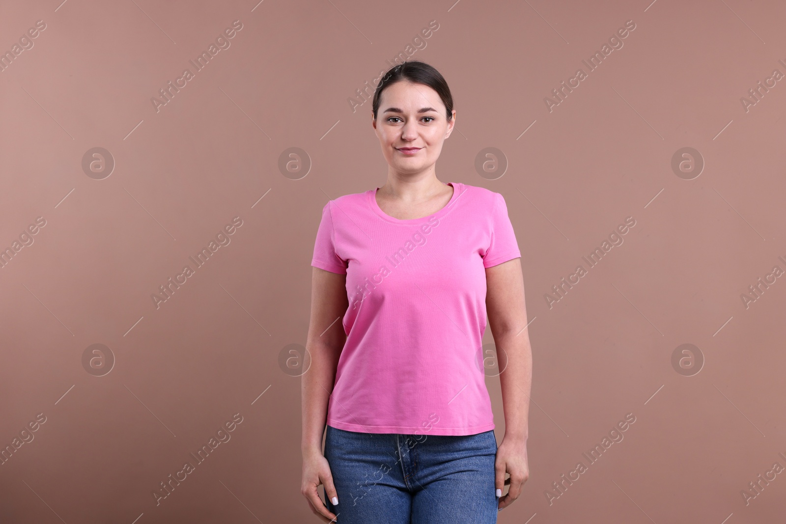 Photo of Woman in pink t-shirt on dark beige background. Mockup for design