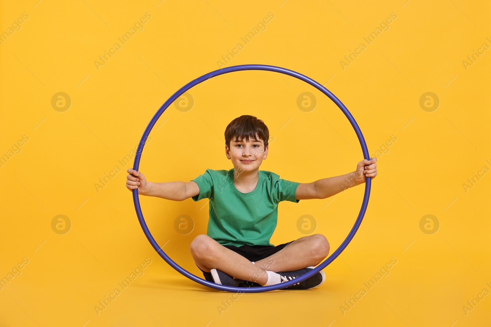 Photo of Boy with hula hoop on yellow background