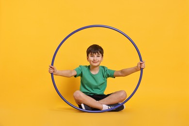 Boy with hula hoop on yellow background