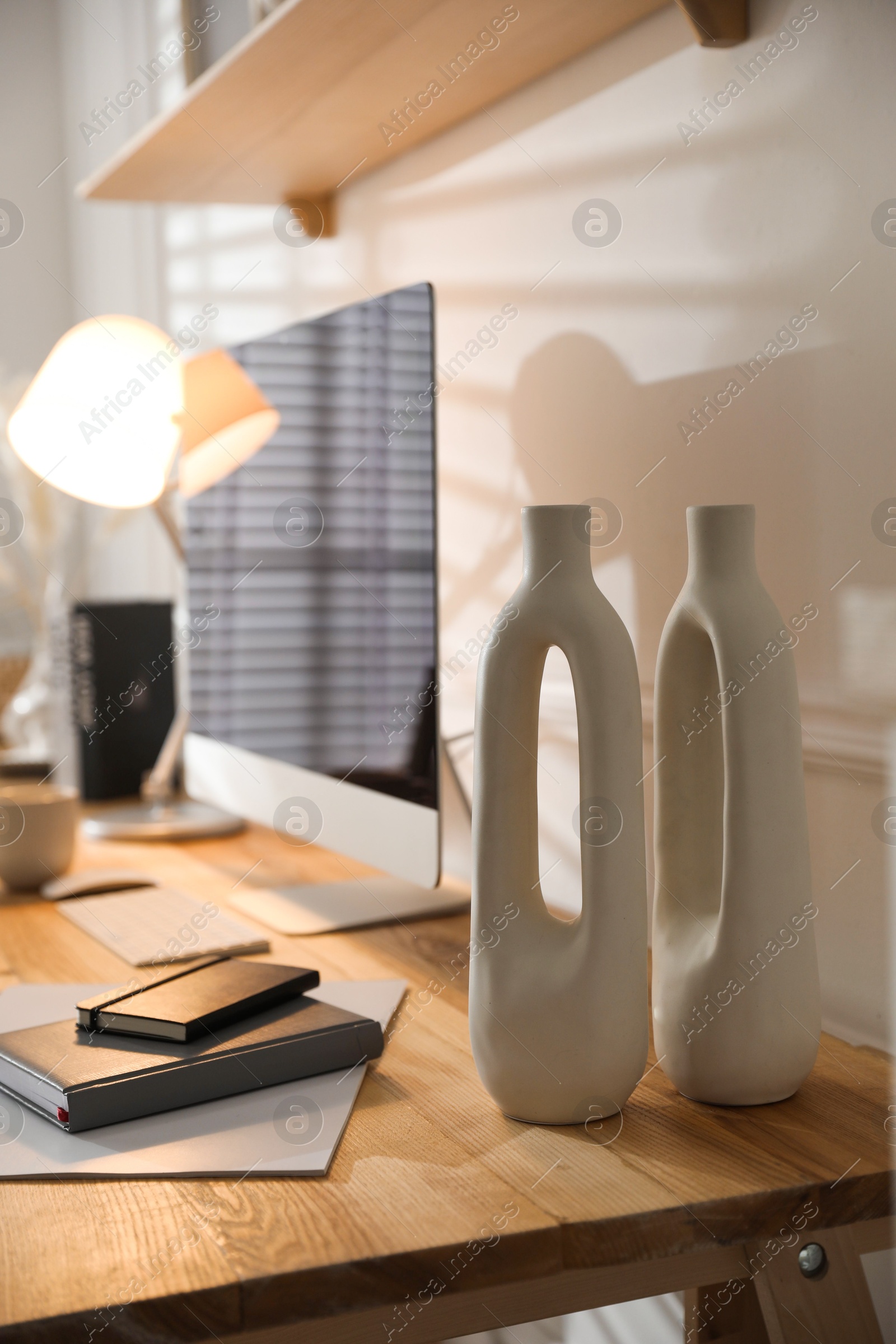 Photo of Comfortable workplace with computer and notebooks in home office, closeup