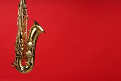 Jazz. One beautiful saxophone on red background, space for text