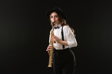 Musician playing soprano saxophone on dark background