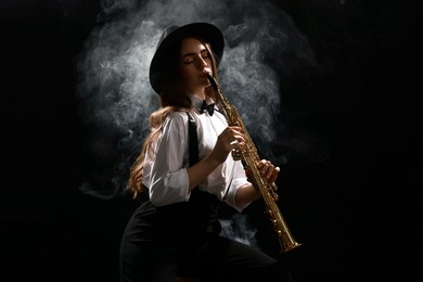 Musician playing soprano saxophone on dark background with smoke