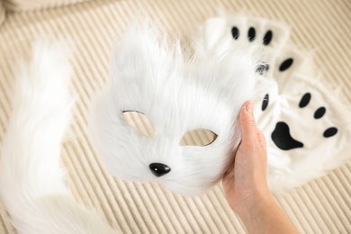 Photo of Quadrobics. Woman with furry cat mask near sofa, closeup