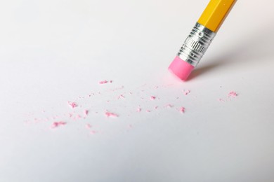 Photo of Using pencil with eraser on white sheet of paper, closeup