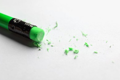 Photo of Pencil with eraser and scraps on white sheet of paper, closeup