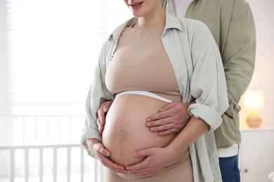 Photo of Pregnant woman and her husband at home, closeup. Space for text