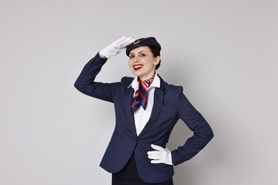 Photo of Portrait of smiling stewardess on grey background