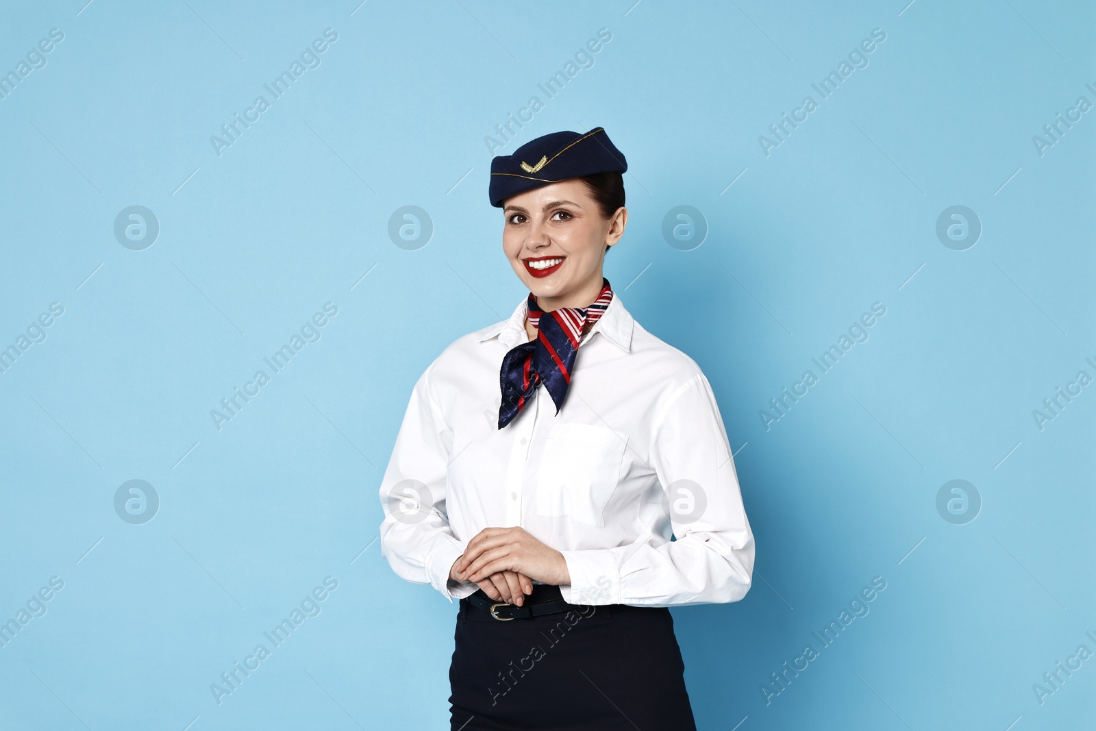 Photo of Smiling flight attendant on light blue background