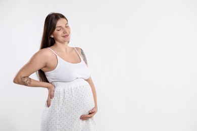 Photo of Beautiful pregnant woman with cute belly on white background. Space for text