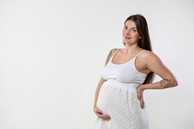 Photo of Beautiful pregnant woman with cute belly on white background. Space for text