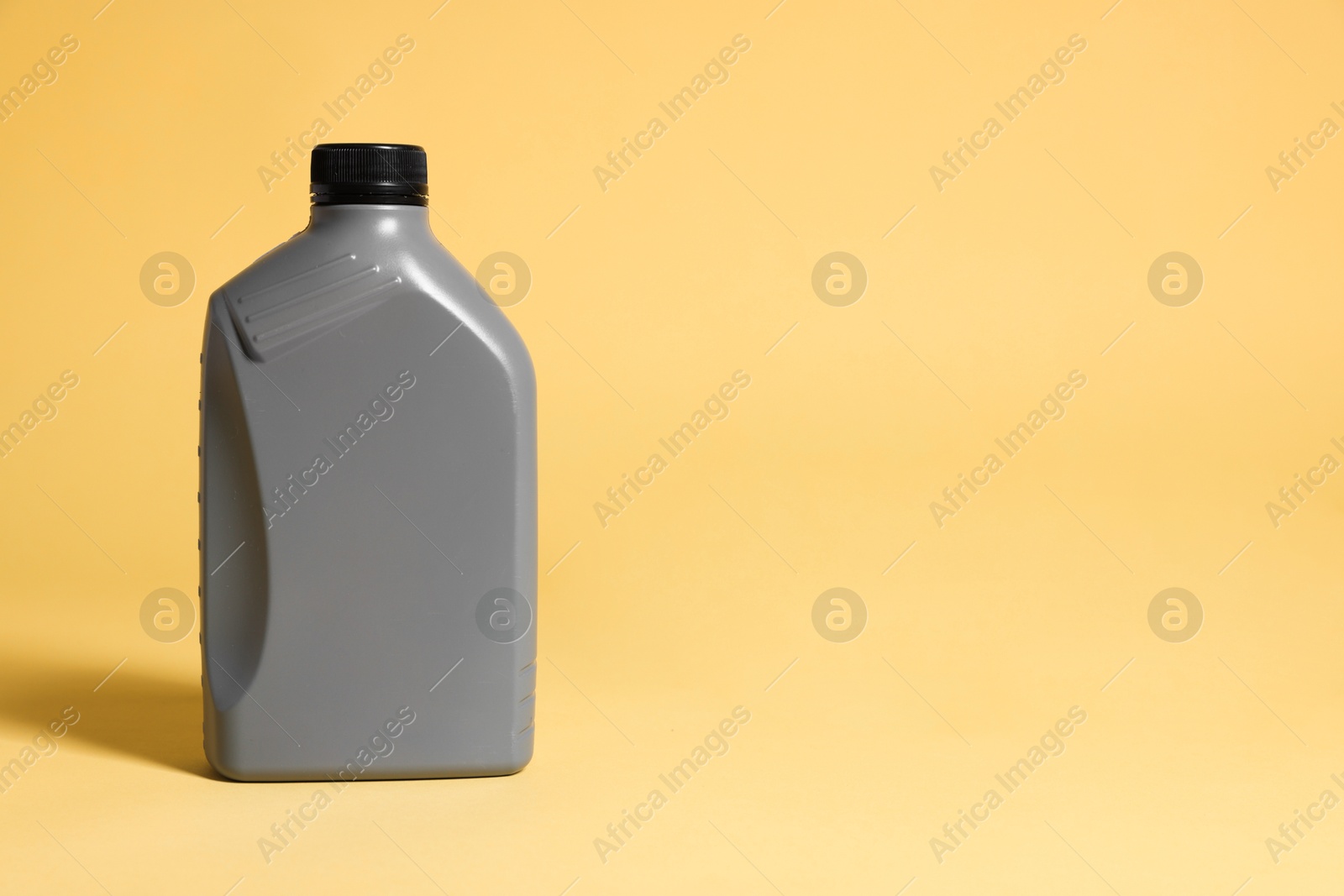 Photo of One grey plastic canister on yellow background, space for text