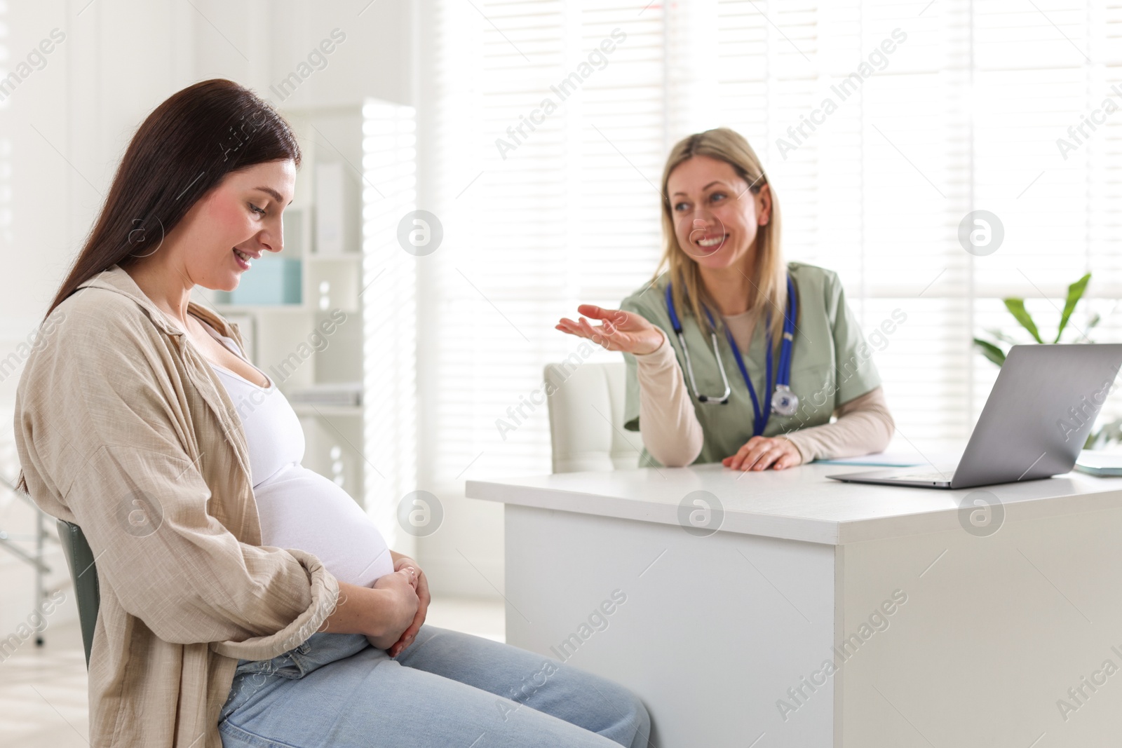 Photo of Pregnant woman having appointment with doctor in clinic