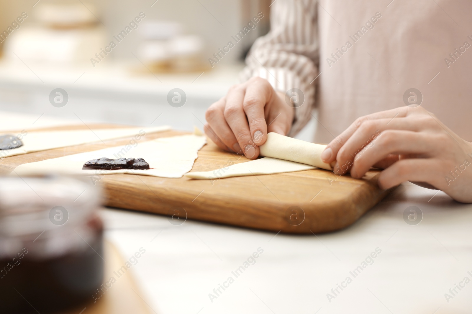 Woman rolling croissant from fresh dough at white table indoors, closeup Photo of Woman rolling croissant from fresh dough at white table indoors, closeup