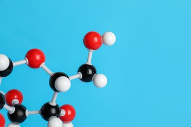 Photo of Molecule of glucose on light blue background, closeup and space for text. Chemical model