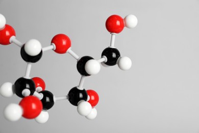 Photo of Molecule of glucose on light grey background, closeup and space for text. Chemical model