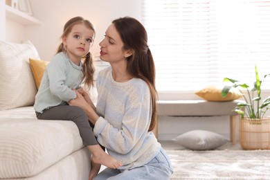 Beautiful mother with her cute little daughter at home