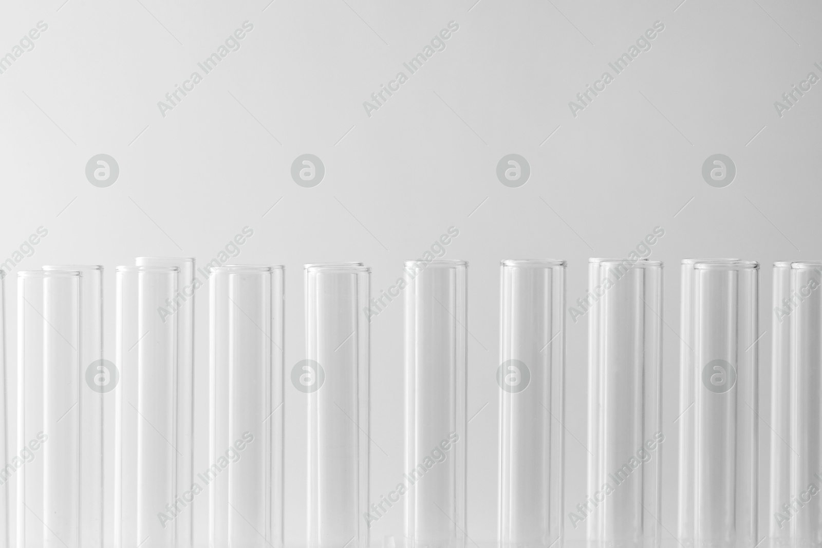 Photo of Empty test tubes on light background, closeup with space for text. Laboratory glassware