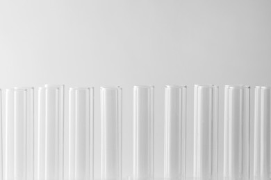 Photo of Empty test tubes on light background, closeup with space for text. Laboratory glassware