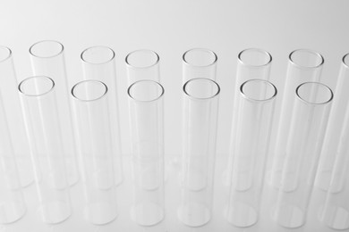 Photo of Empty test tubes on light background, closeup. Laboratory glassware